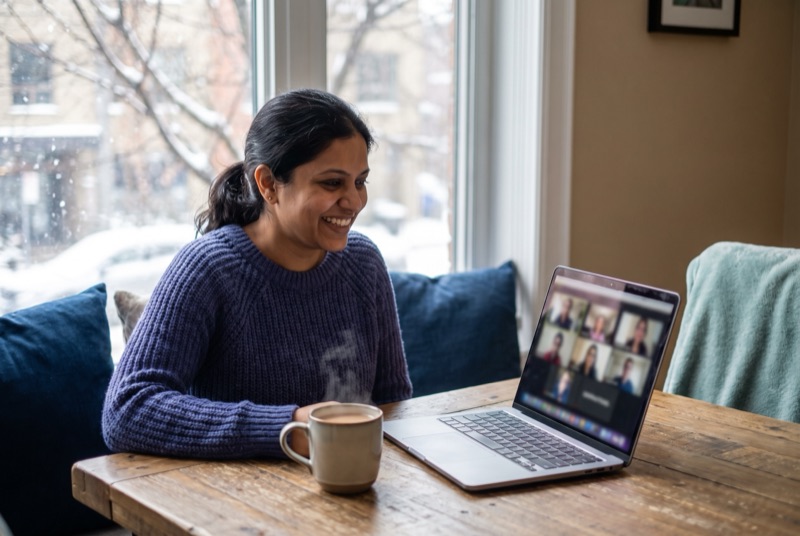 A woman in a snowy city smiling during a video call